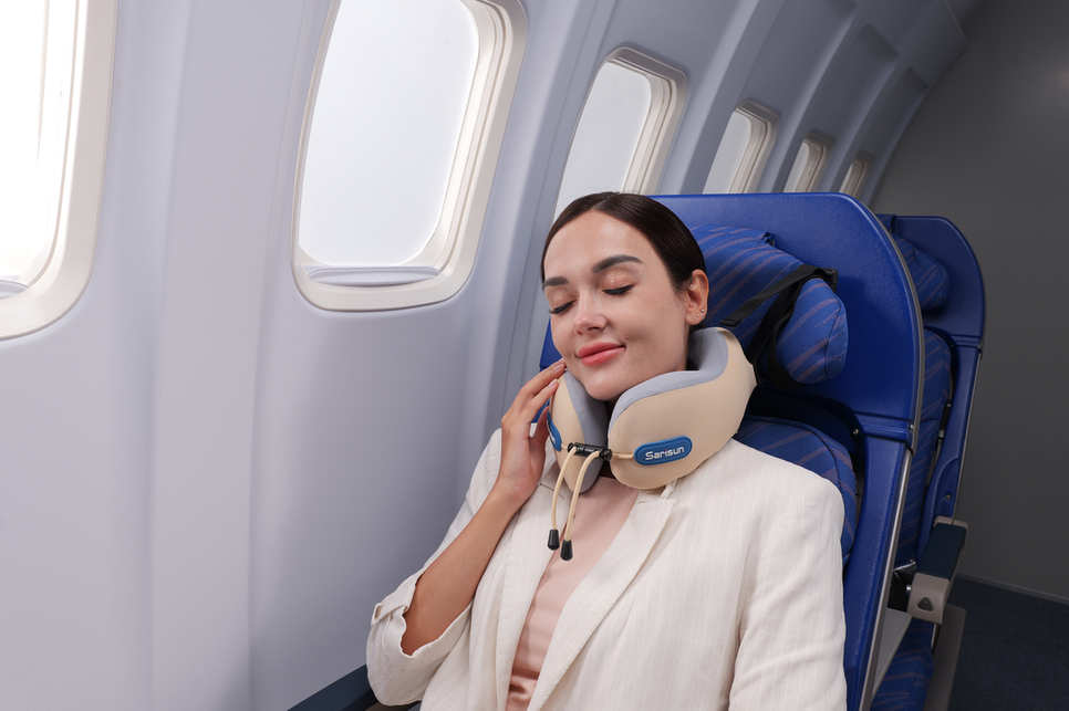 Traveler sleeping upright in an airplane seat with a travel neck pillow supporting the head and neck