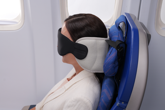 Airplane passenger resting with adjustable headrest wings beside the window